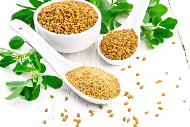 istock Fenugreek in two spoons and bowl with leaves on light board 1216598154