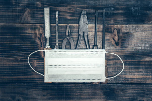 istock Labor day concept on wood background. Engineer and worker tools with construction safety equipment and mask. Safety first concepts 1216598232