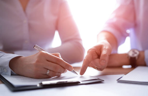 Business people negotiating a contract. Business people negotiating a contract. Human hands working with documents at desk and signing contract. witness signature stock pictures, royalty-free photos & images