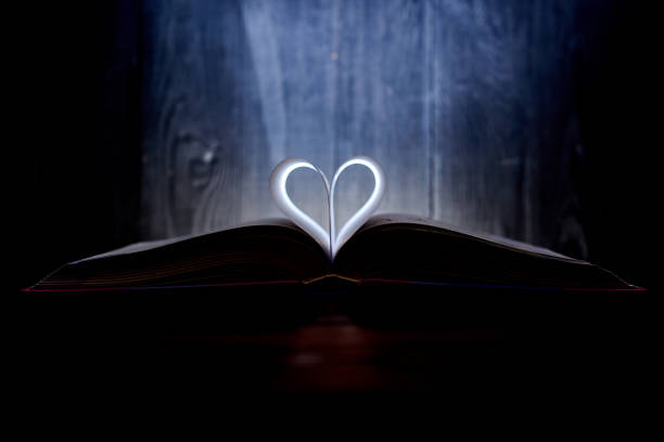 istock A heart from book pages shines in the dark. 1216600022