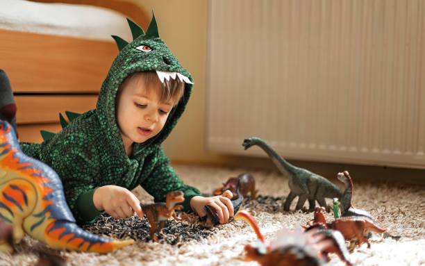 istock Adorable boy playing with his dinosaurs 1216600896