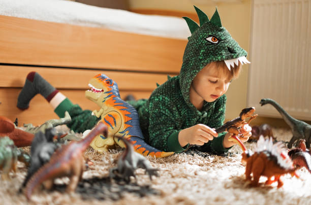 istock Adorable boy playing with his dinosaurs 1216600943