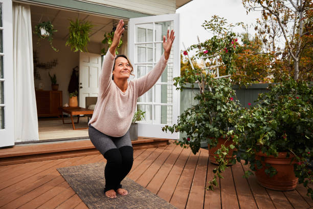 istock Smiling mature woman practicing her chair pose outside 1216602995