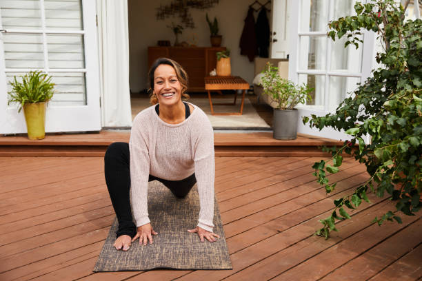 istock Mature woman smiling while practicing yoga on her deck 1216603663
