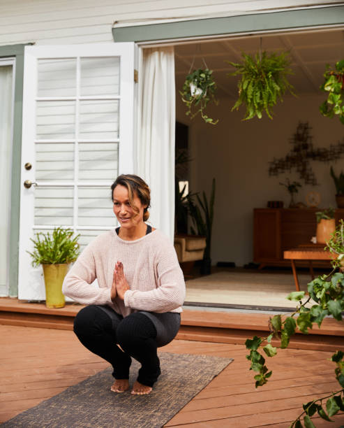 istock Mature woman smiling and practicing yoga on her patio 1216604363