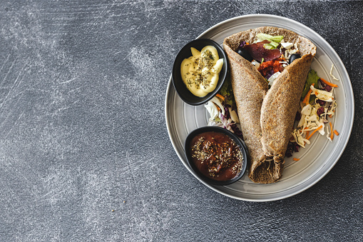 Tortilla wrap with organic vegetable on dark background