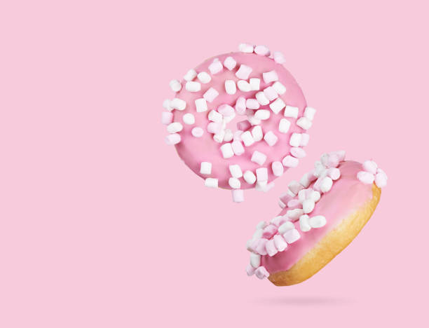 istock two donuts with marshmallow isolated on pink background 1216604701