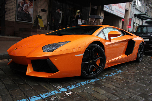 Kiev, Ukraine; July 1, 2012; Lamborghini Aventador on the streets. Car. Orange. City. Luxurious. Tuning. Supercar. The car in the rain. Raindrops