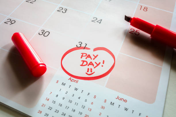 Payday end of month date on calendar with red marker and circled day of salary Payday end of month date on calendar with red marker and circled salary day paycheck photos stock pictures, royalty-free photos & images