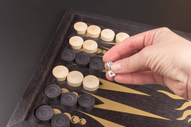 istock Detail of a backgammon game with two dice close up, on black. Dice on backgammon board game. Selective focus. Playing leisure games 1216607076