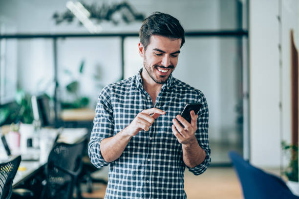 istock Smiling businessman using smart phone in the office. 1216607315