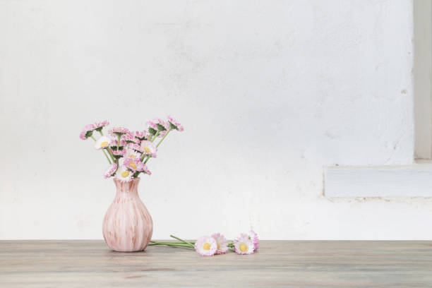 istock daisy flowers in pink vase on wooden table 1216608511
