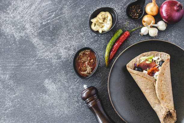 Vegan wrap Vegan wrap in plate on dark background mexican culture food mexican cuisine fajita stock pictures, royalty-free photos & images