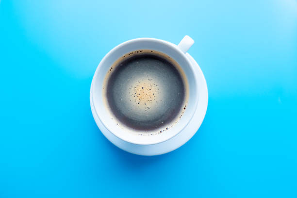 istock black coffee in a coffee cup top view isolated on blue background. with clipping path. 1216610348