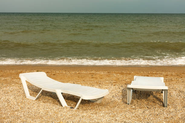 Plastic sunbeds on the golden beach. Sea view