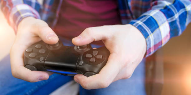 istock Man wearing checkered shirt playing video game 1216614542