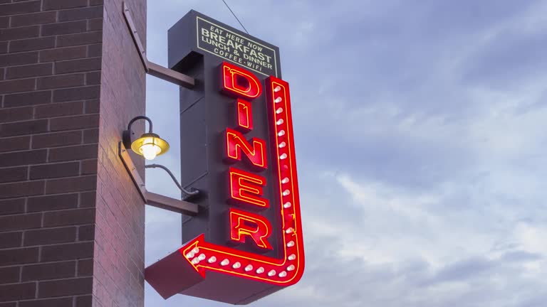 A Timelapse of a Neon Diner Sign and Cloudy Sky