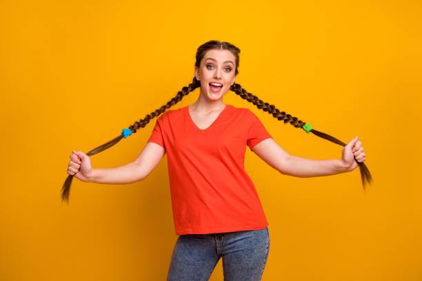 Photo of attractive pretty funny lady hold hands two long pigtails weekend good mood rejoicing playful wear casual red t-shirt jeans isolated vibrant yellow color background Photo of attractive pretty funny lady hold hands two long pigtails, weekend good mood rejoicing playful wear casual red t-shirt jeans isolated vibrant yellow color background Pigtails stock pictures, royalty-free photos & images