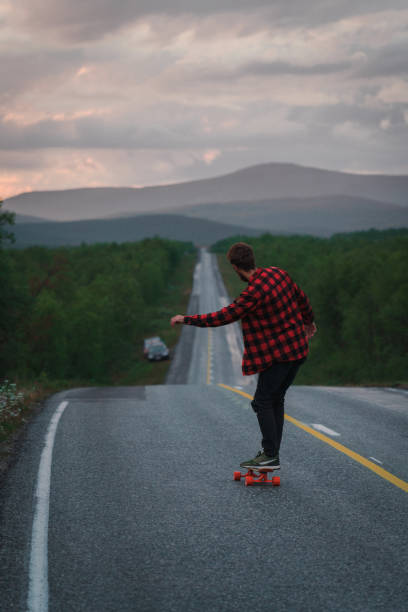 istock Man longboarding  on the road in Finland 1216619218