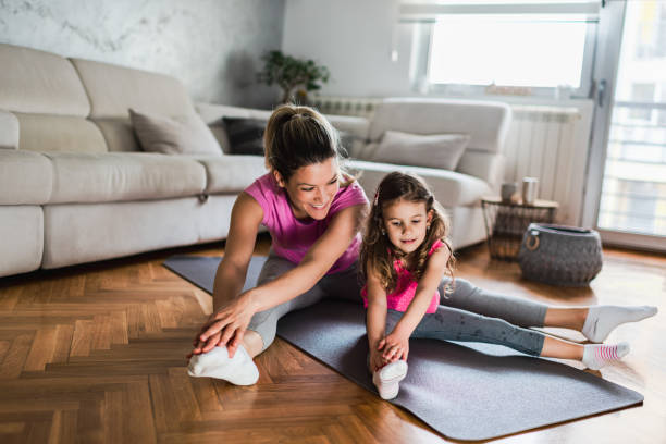 matka praktykuje jogę z córeczką w domu - yoga flexibility two people women zdjęcia i obrazy z banku zdjęć