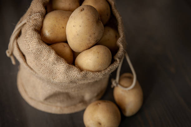 istock Potatoes in sackcloth on rustic wooden background 1216624045