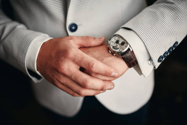 businessman checking time on his wrist watch, man putting clock on hand,groom getting ready in the morning before wedding ceremony. man puts on a watch. selective focus businessman checking time on his wrist watch, man putting clock on hand,groom getting ready in the morning before wedding ceremony. man puts on a watch. selective focus necktie fashion adjusting suit stock pictures, royalty-free photos & images