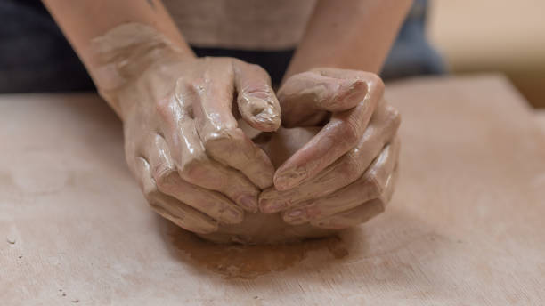 istock Workflow of a woman working behind a pottery wheel in an art workshop. Unknown master creates a jug. Focus only on the hands. Small business, talent, invention, hobby concept, inspiration. 1216628486