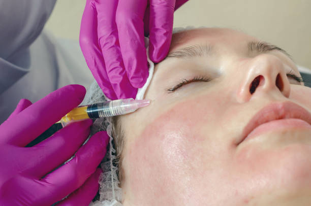 istock Woman face makes beauty injections around eyes, syringe 1216632578