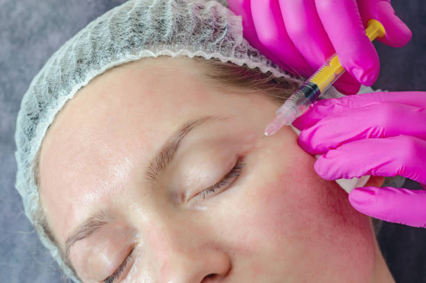 istock Woman face makes beauty injections around eyes, syringe 1216634479