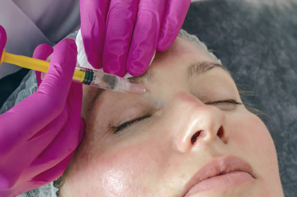 istock Woman face makes beauty injections around eyes, syringe 1216634566