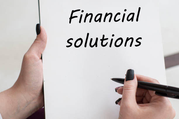 istock words FINANCIAL SOLUTIONS writes girl on a blank white sheet 1216636707
