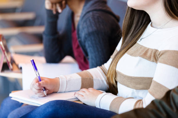 istock Unrecognizable female college student takes notes in class 1216637008