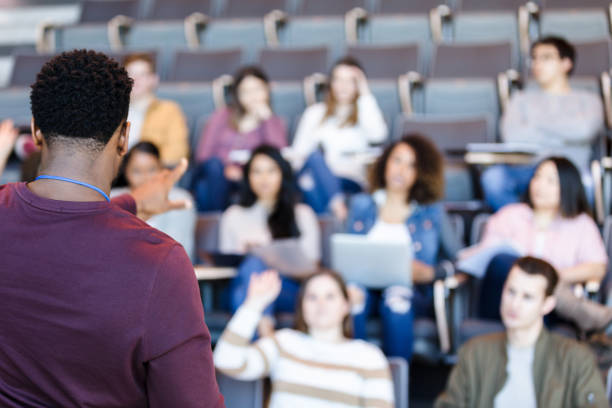 istock Mid adult male college professor calls on student in front row 1216637021