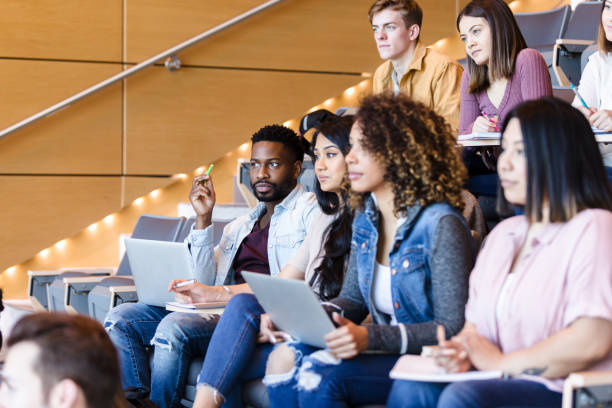 多様な学生がゲスト講師のプレゼンテーションに関心を持っています - lecture hall college student university multi ethnic group ストックフォトと画像