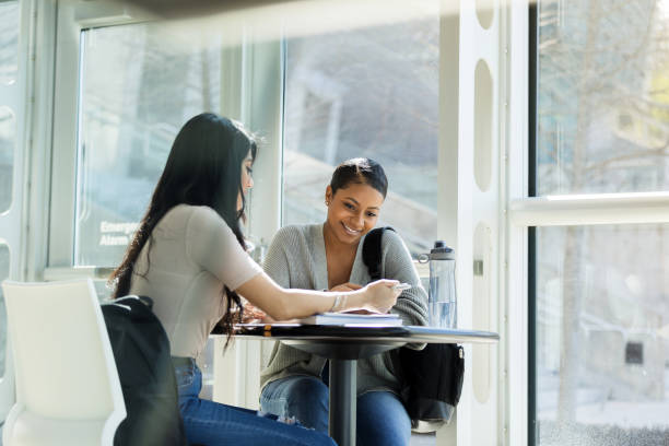 istock Smiling African American female student studies with friend 1216637625