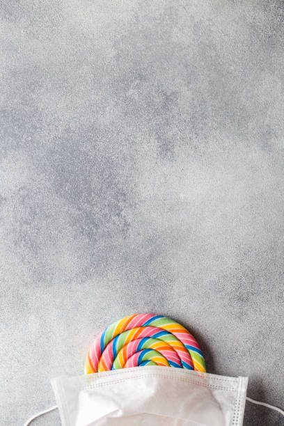 istock multi colored lollipop covered medical mask top view flat lay copy space 1216638636