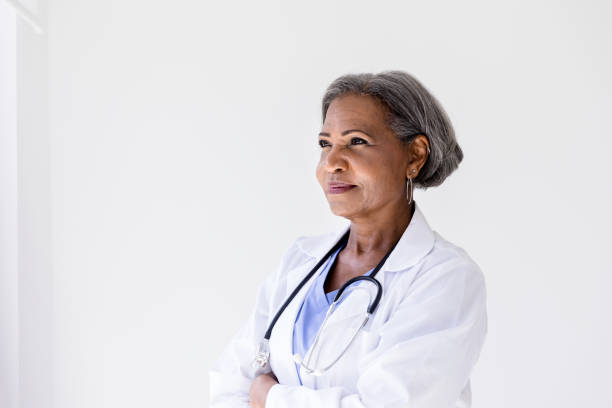 istock Attractive mature doctor stands in deep thought 1216638754