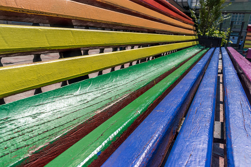 close-up of a park bench with rainbow colors in a square in Spain