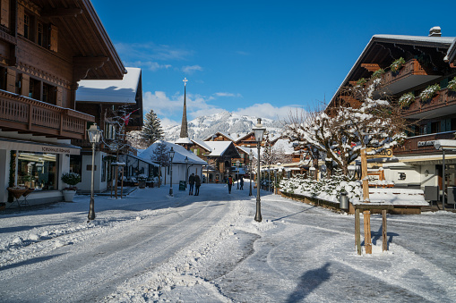 Gstaad/ Switzerland - 10.01.2019: Gstaad promenade in snow covered Gstaad village center with its chalet