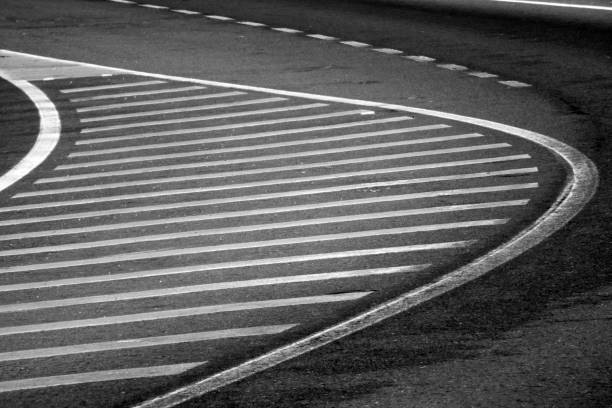 Horizontal road markers, traffic island , lane. Black and white view from above , perspective, abstract. A Coruna province, Galicia, Spain.White lines on black asphalt.