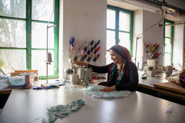 One peasant woman workshop tailor clothing manufacturing stock photo