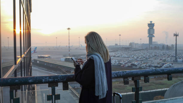 mujer se relaja fuera del aeropuerto al amanecer - using laptop contemplation accessibility contemporary fotografías e imágenes de stock