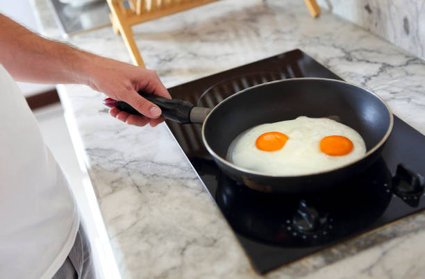 przycięty obraz człowieka gotującego jajecznicę na patelni - eggs fried egg frying pan fried zdjęcia i obrazy z banku zdjęć