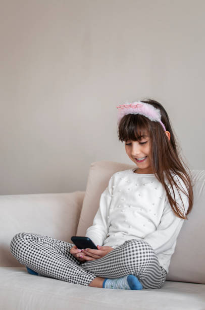 istock Littel girl using mobile phone at home 1216646522
