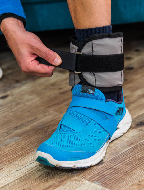istock Close up of a man closing velcro strap on ankle weight 1216648547
