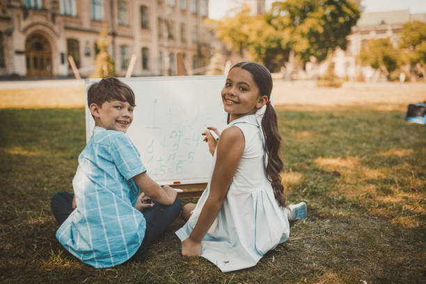 istock Cheerful Kids Writing Numbers On Whiteboard in nature 1216648746
