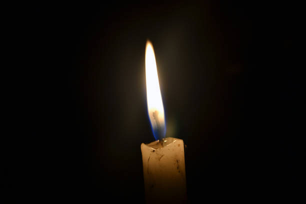 istock single candle burning in the dark 1216651317