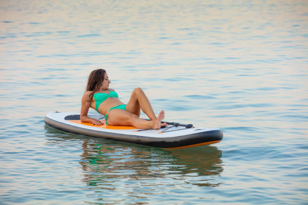 istock Attractive brunette on stand up paddle board 1216651337