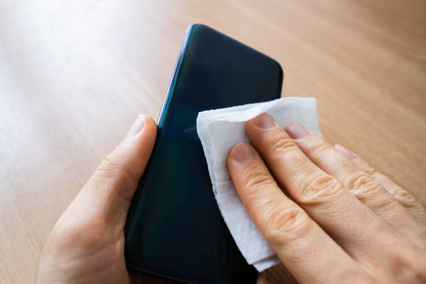 istock Man Wiping Mobile Phone With Sanitizer 1216652228