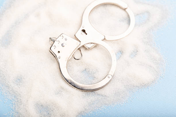 istock Sugar is dangerous. Handcuffs on the table. Sweet dependence. 1216652368